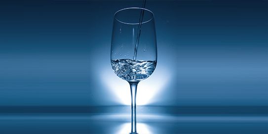 Ein Glas Wasser vor einem blauen Hintergrund